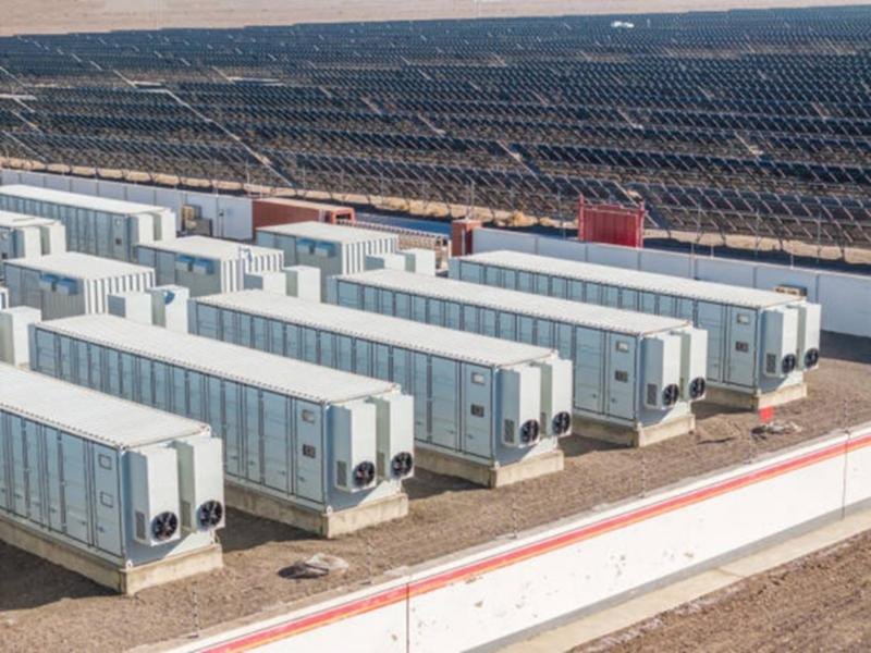 Battery storage containers beside a solar field